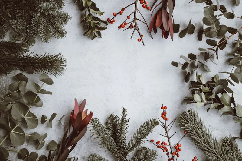 A festive Christmas event scene with shimmering holiday decorations, including twinkling string lights, evergreen garlands draped across the room, and warm golden ornaments creating a cheerful party atmosphere filled with Christmas spirit.