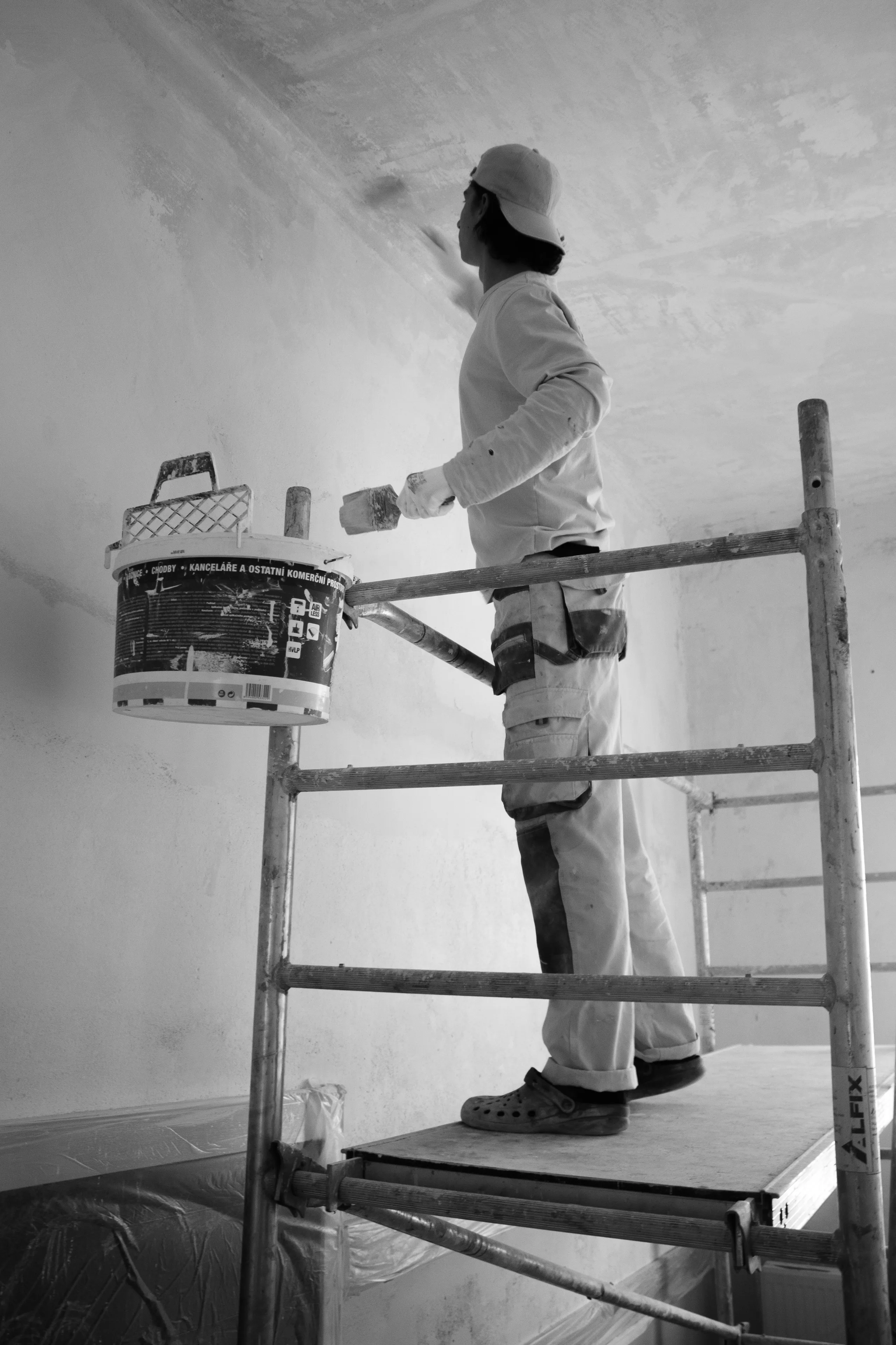 Painter applying paint to wall with roller