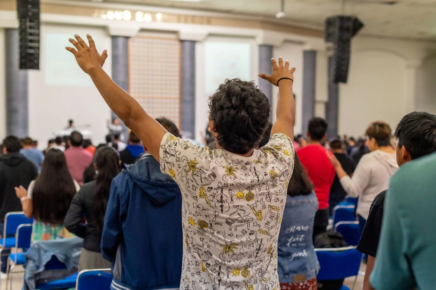 Teens with hands raised in worship at Youth Church