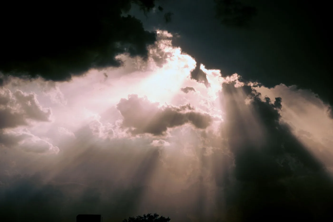 Sunlight breaking dramatically through dark clouds