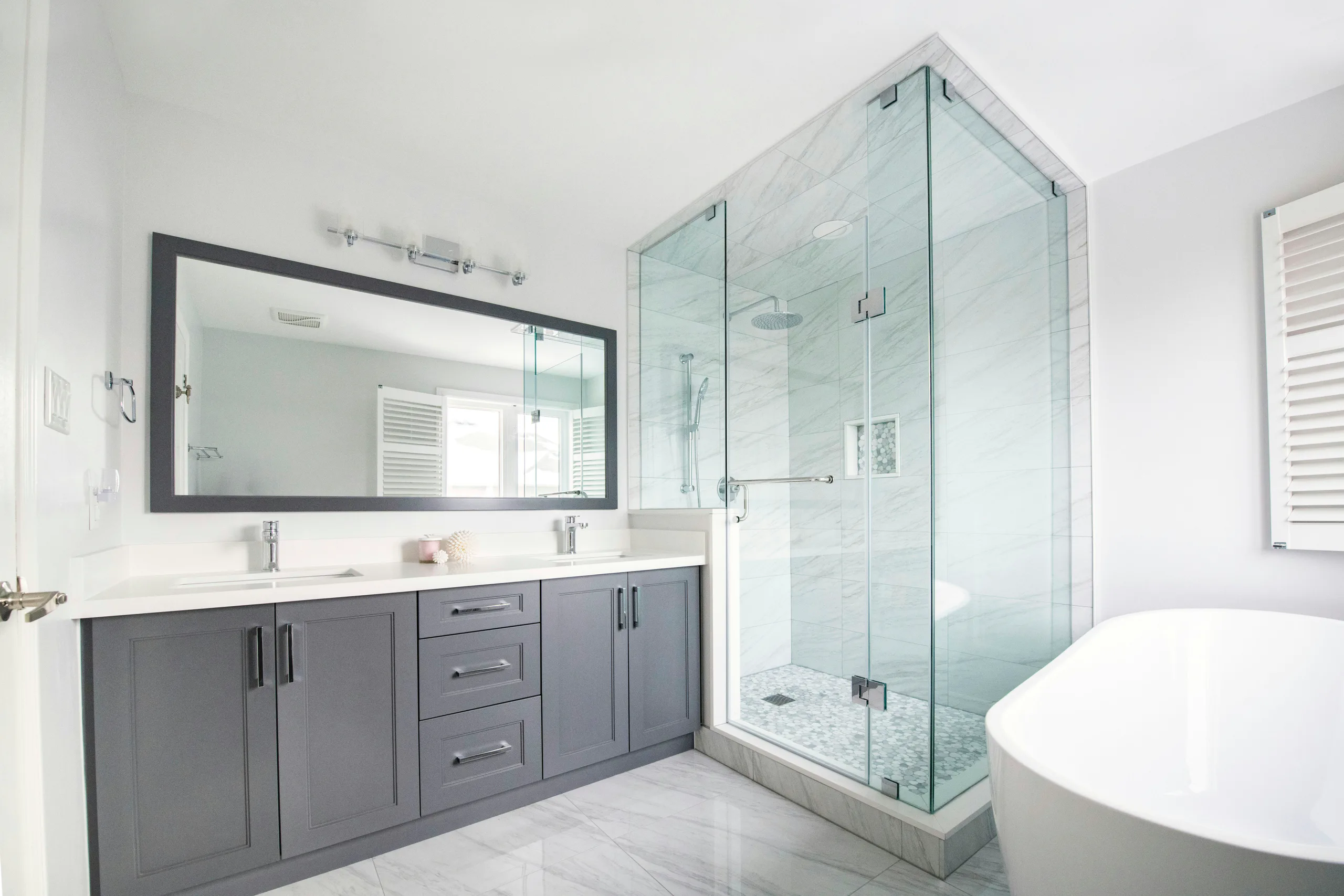 Newly renovated bright bathroom with glass shower and freestanding bathtub in a Dublin home
