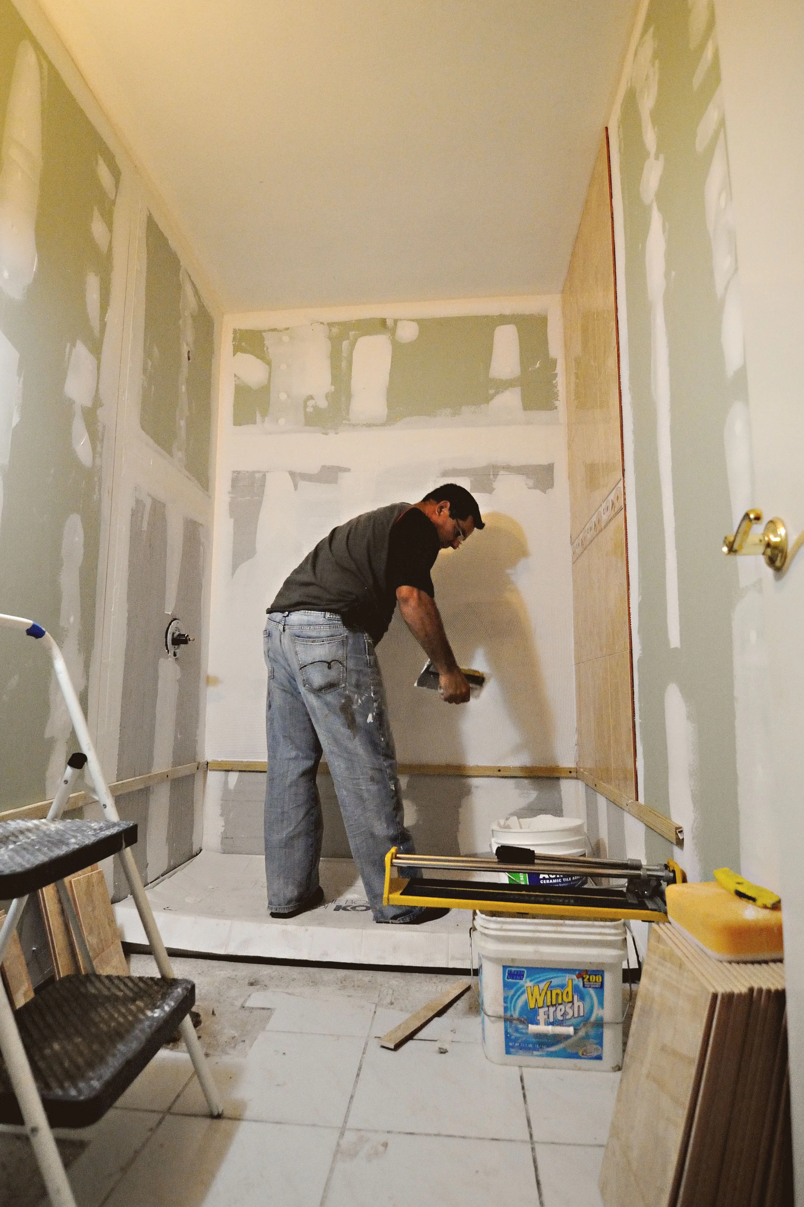 Professional tiler measuring and laying floor tiles