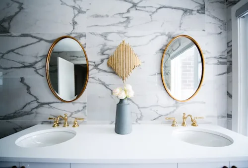 Bright marble and gold bathroom with two sinks, en suite tiling Dublin