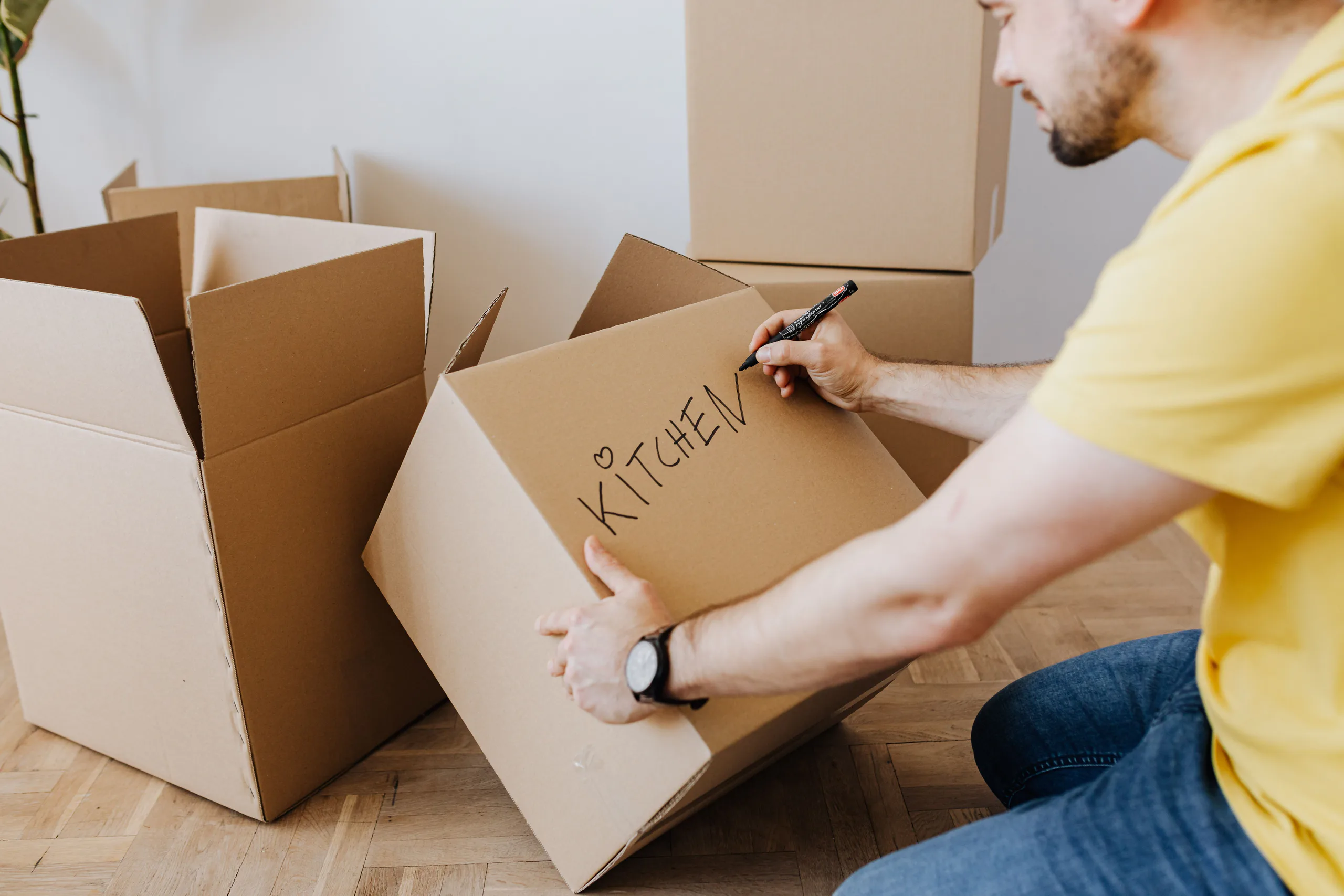 New homeowner labeling a moving box in a bright room