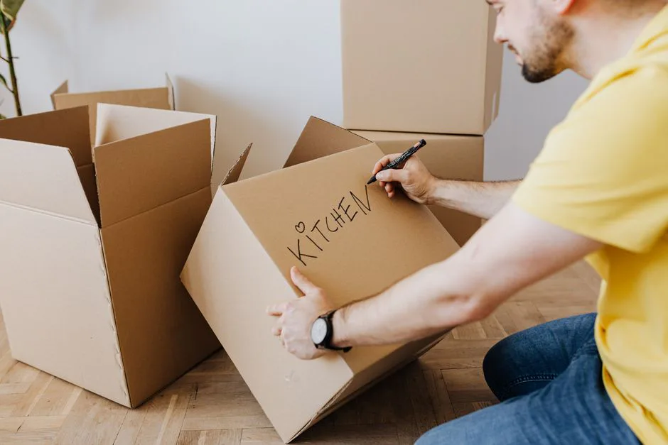 New homeowner labeling a moving box in a bright room