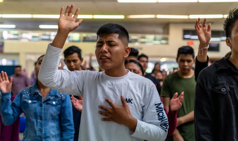 Young people worshiping with hands raised