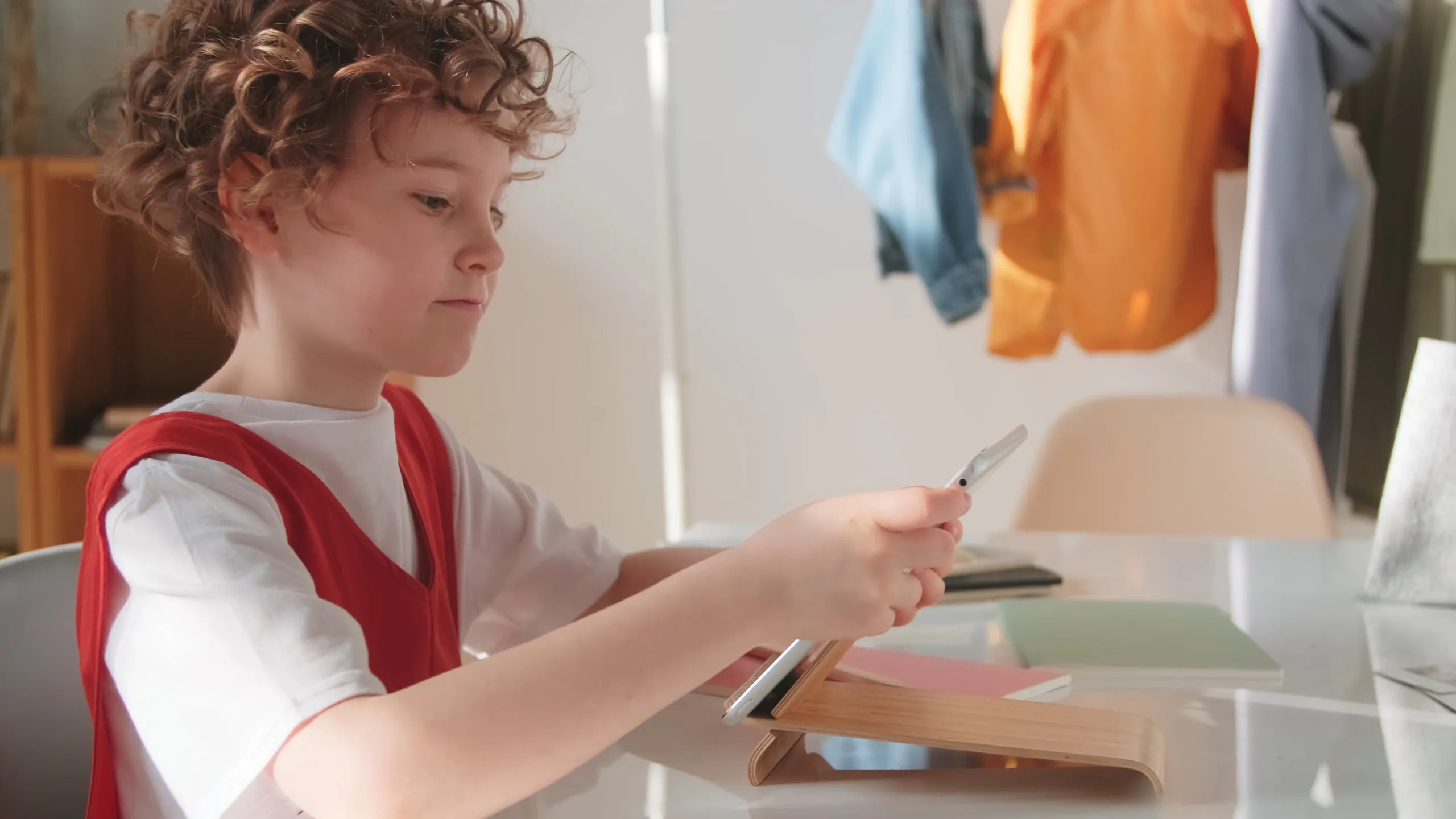 A child interacting with a tablet showing a grid of visual communication cards