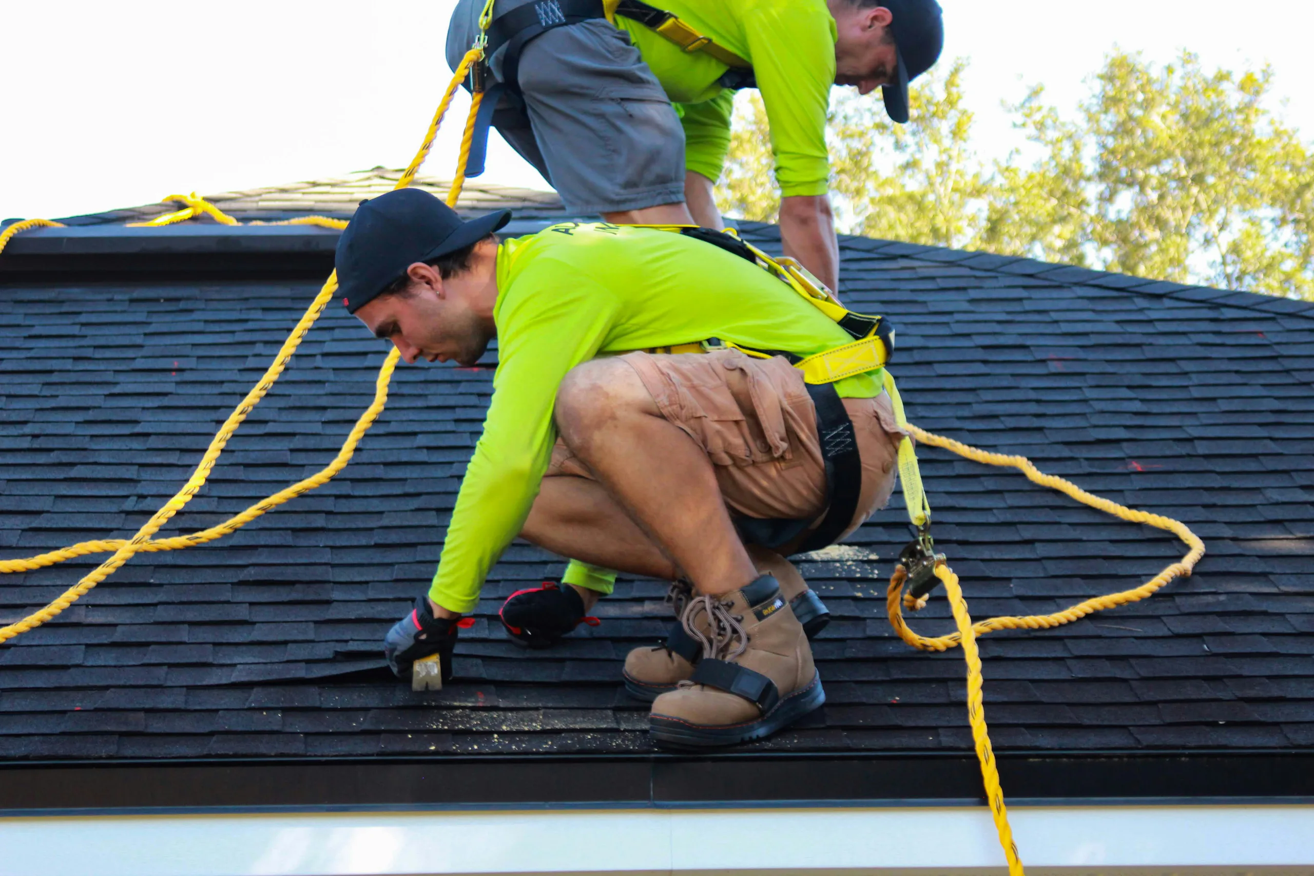 Two roofers working together on a residential roof in Smithtown NY