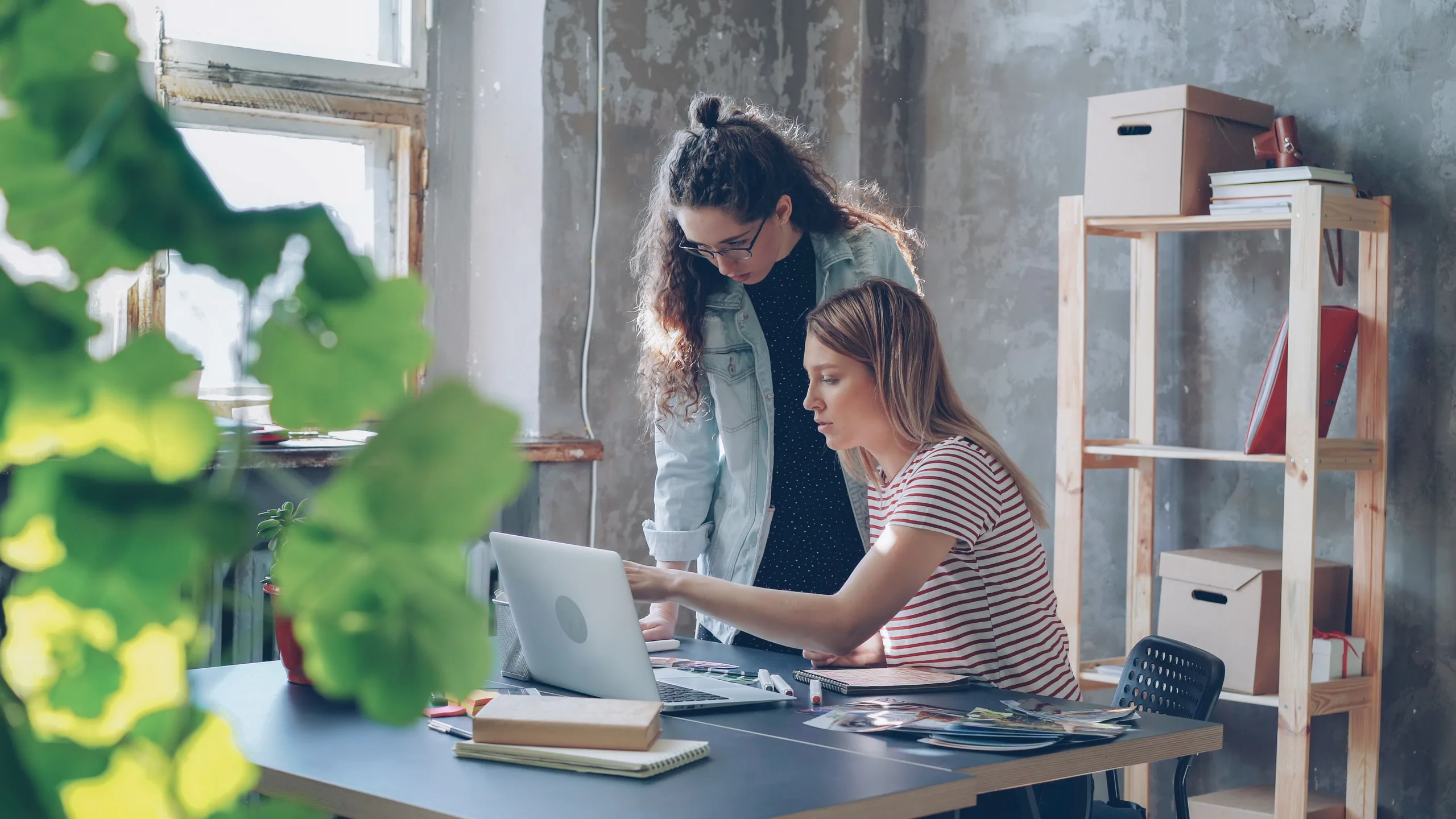 Two professionals developing a project beside a laptop