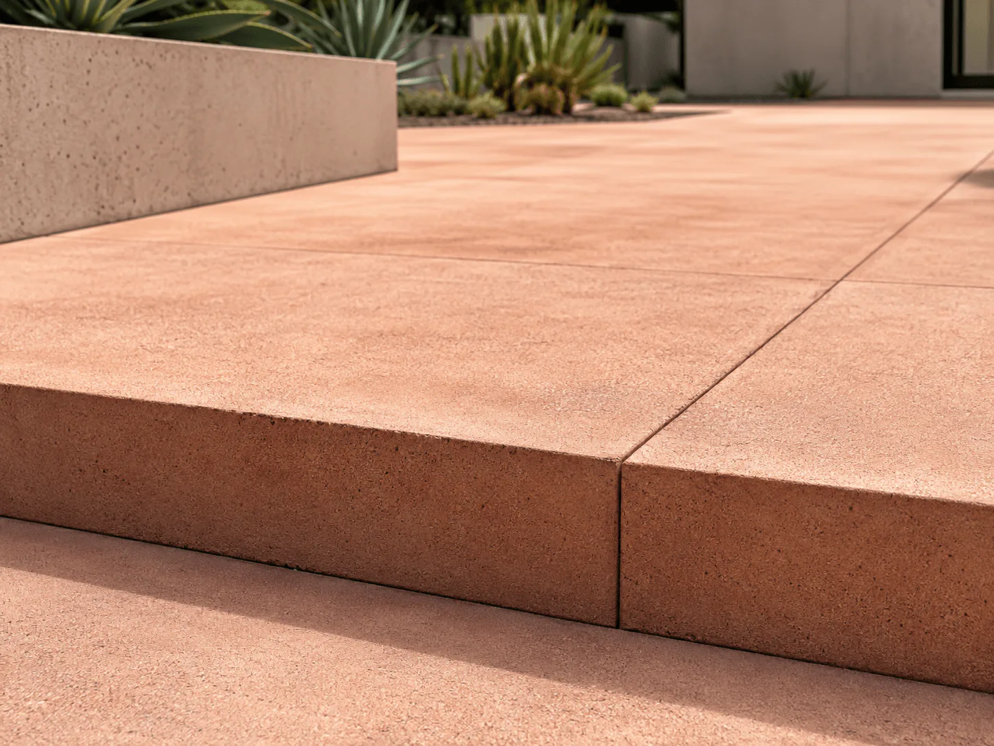 Warm terracotta integral-color concrete paving with subtle mottling