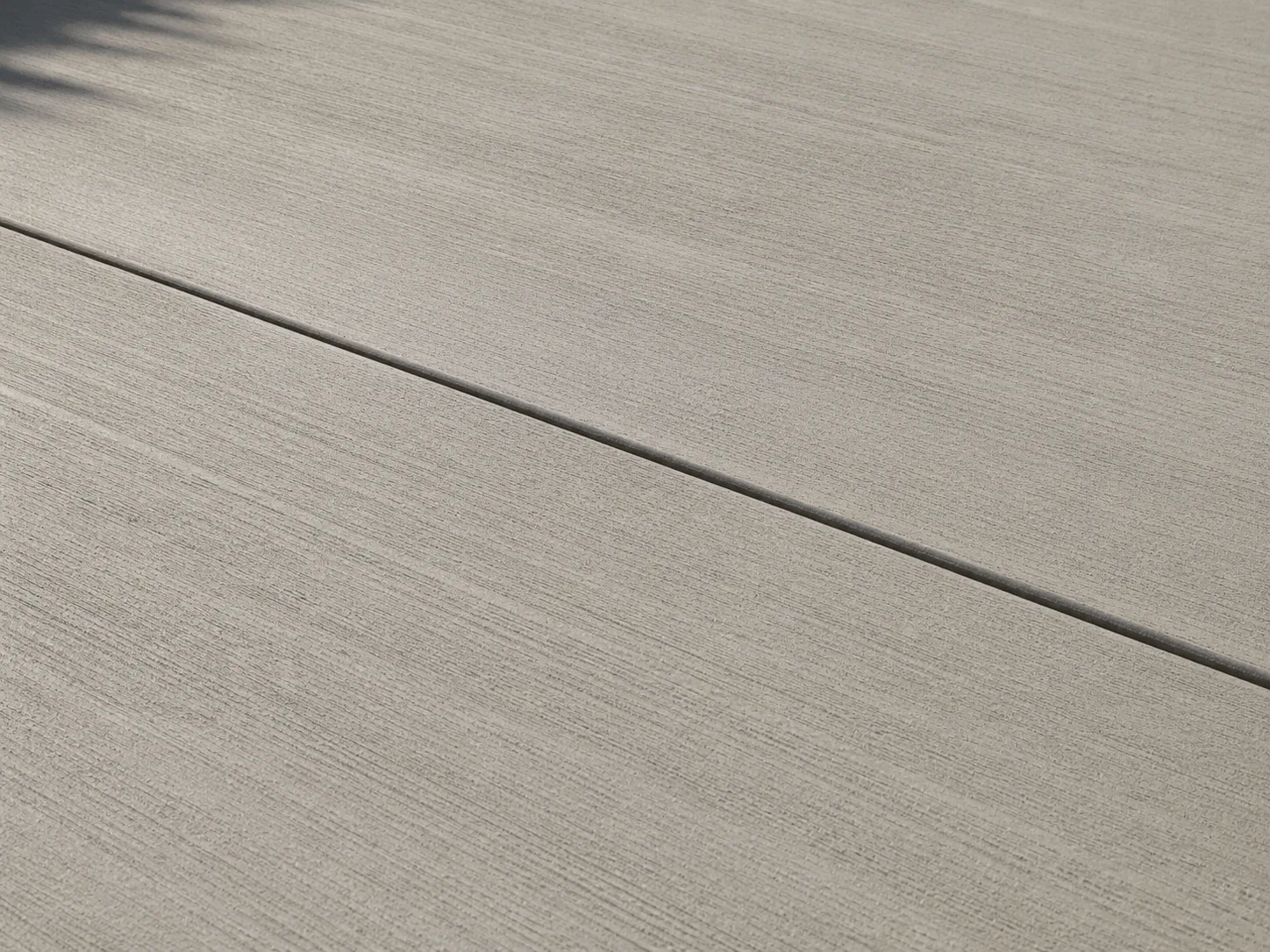 Fine straight broom lines across light gray concrete