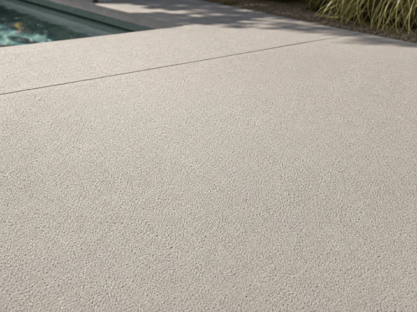 Pale concrete with a fine sand-float texture beside a pool