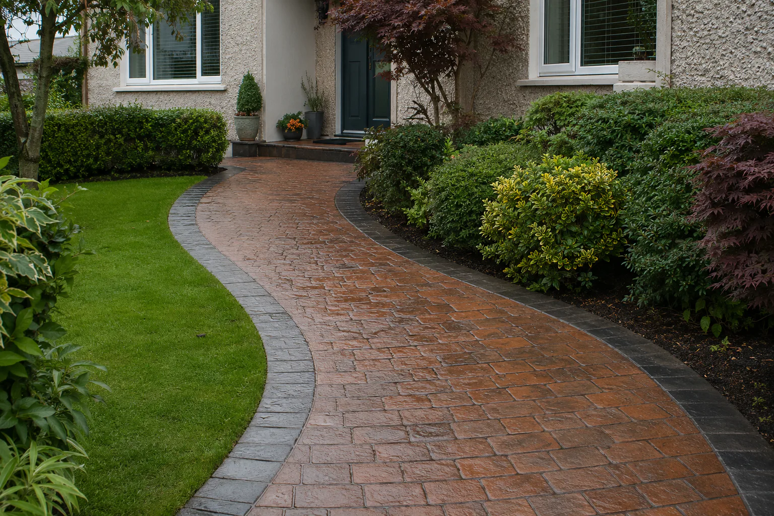 Terracotta patterned concrete path with dark border and garden planting