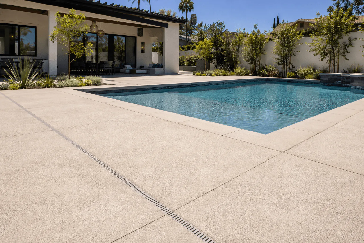 Light textured concrete pool deck with drainage at an Anaheim area home
