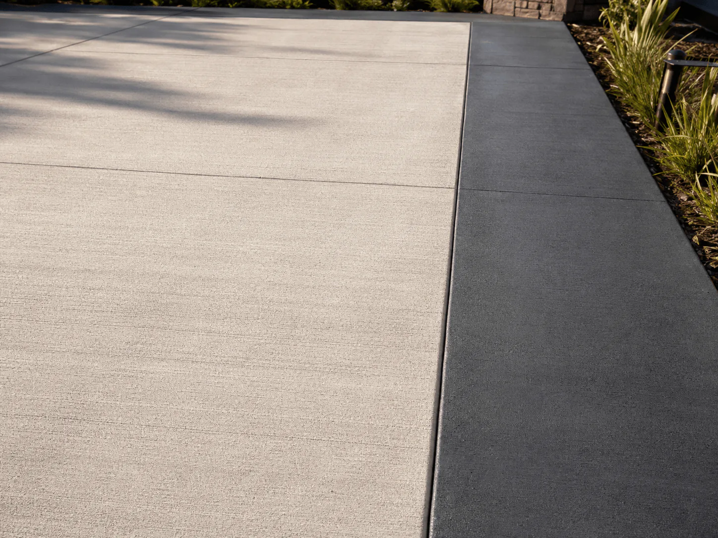 Light concrete patio framed by a dark charcoal decorative border