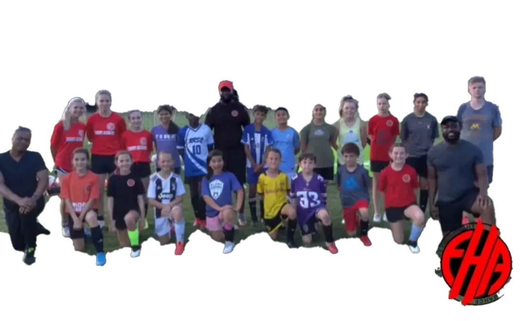 Coach Mulenga, coaching staff and youth athletes posing on a soccer field.