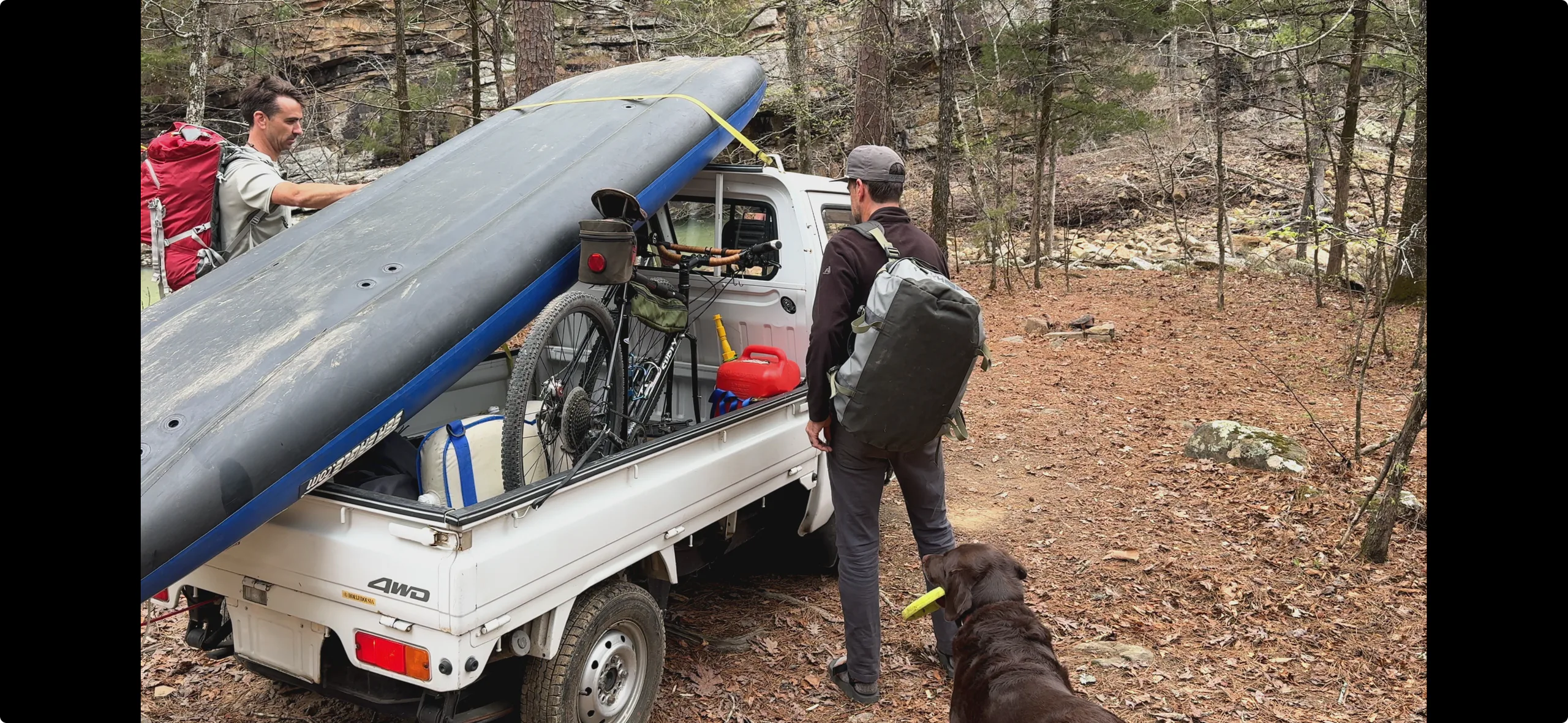 Two men loading outdoor gear onto a mini truck in Northwest Arkansas